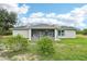 Charming backyard showcasing a screened-in porch and ample green space at 38 Malauka Dr, Ocklawaha, FL 32179