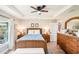 Charming bedroom with a ceiling fan, wood furniture, and a view to the outside at 38 Malauka Dr, Ocklawaha, FL 32179