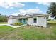 Gray home with blue chairs and a cute blue door at 38 Malauka Dr, Ocklawaha, FL 32179