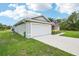 The home has a two-car garage and well maintained lawn at 38 Malauka Dr, Ocklawaha, FL 32179