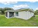 Property exterior with a screened-in patio, clean lines, and well-kept lawn at 38 Malauka Dr, Ocklawaha, FL 32179