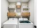 Efficient laundry room with white appliances and shelving for storage at 38 Malauka Dr, Ocklawaha, FL 32179