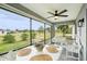 Inviting sunroom with ceiling fan, a hanging swing, and a table for enjoying serene outdoor views at 38 Malauka Dr, Ocklawaha, FL 32179
