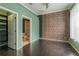 Stylish bedroom featuring hardwood floors, a brick accent wall, and an ensuite bathroom at 415 Old Farm Ln, Winter Springs, FL 32708
