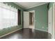 Bright bedroom featuring hardwood floors, neutral walls, and a window overlooking the lush greenery at 415 Old Farm Ln, Winter Springs, FL 32708