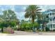 Community entrance with lush landscaping, palm trees, and charming architecture at 415 Old Farm Ln, Winter Springs, FL 32708