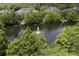 Scenic view of a pond featuring a fountain, surrounded by lush trees and charming homes at 415 Old Farm Ln, Winter Springs, FL 32708
