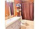 Functional bathroom features a grey vanity, a toilet, and a shower-tub combo with a curtain at 4235 Shades Crest Ln, Sanford, FL 32773