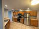 Kitchen with stainless steel appliances, oak cabinets, and tile floors for easy maintenance at 4503 Oak Arbor Cir, Orlando, FL 32808