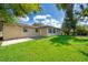 Exterior view of home's rear, showcasing the spacious, green backyard with ample sunlight and room for outdoor activities at 4524 King Cole Blvd, Orlando, FL 32811