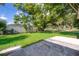 Spacious, grassy backyard with mature tree, concrete patio and partial fence for a relaxing outdoor living space at 4524 King Cole Blvd, Orlando, FL 32811