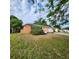 Exterior angle view of single story home with an orange facade and well manicured lawn at 4840 Judy Ann Ct, Orlando, FL 32808