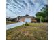 A quaint one-story home, featuring a light orange color and a lengthy driveway to the two car garage at 4840 Judy Ann Ct, Orlando, FL 32808