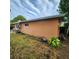 Exterior shot of the side of a home, with overgrown landscaping at 4840 Judy Ann Ct, Orlando, FL 32808