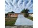 Lovely one-story home showcasing a bright orange facade and a lengthy concrete driveway at 4840 Judy Ann Ct, Orlando, FL 32808