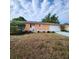 Exterior shot of an orange house with a white door, garage, and lots of potted plants lining the walkway at 4840 Judy Ann Ct, Orlando, FL 32808