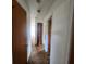 Hallway with carpet and wooden doors leading to different rooms within the home at 4840 Judy Ann Ct, Orlando, FL 32808
