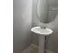Bathroom with a pedestal sink and round mirror at 514 Wilton Cir, Sanford, FL 32773
