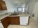Kitchen with stainless steel sink, wooden cabinetry, and white appliances at 514 Wilton Cir, Sanford, FL 32773