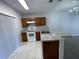 Kitchen featuring stainless steel sink, modern appliances, and white tile floors at 514 Wilton Cir, Sanford, FL 32773