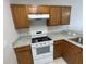 Kitchen featuring modern white appliances, wooden cabinets, and durable countertops at 514 Wilton Cir, Sanford, FL 32773