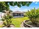 View of the backyard with mature landscaping, a well-kept lawn, and a screened-in lanai for outdoor enjoyment at 520 Farmingham Ct, Oviedo, FL 32765
