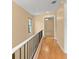 Upstairs hallway with wood floors, offering natural light, and views of the backyard from a large window at 609 Northbridge Dr, Altamonte Springs, FL 32714