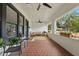 Charming front porch featuring comfortable seating, brick flooring, and ceiling fans at 641 E Livingston St, Orlando, FL 32803