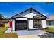 Charming one-story home featuring a black garage door and a red front door at 6856 Ebans Bend, Orlando, FL 32807