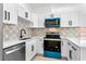 Kitchen featuring modern appliances, stylish backsplash and white cabinets at 6856 Ebans Bend, Orlando, FL 32807