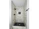 Modern shower featuring marble-look tile, black fixtures, and black honeycomb tile niche and floor at 6856 Ebans Bend, Orlando, FL 32807
