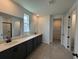 Modern bathroom featuring a double sink vanity, neutral tile, and a separate toilet room and walk-in closet at 707 Junonia Blvd, New Smyrna Beach, FL 32168