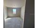 Cozy bedroom with window view, unfinished walls, and concrete floors at 707 Junonia Blvd, New Smyrna Beach, FL 32168