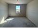 Bedroom with a window view, unfinished walls, and concrete floors at 707 Junonia Blvd, New Smyrna Beach, FL 32168