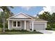 Charming single-story home boasts gray siding, complemented by well-manicured landscaping and a spacious two-car garage at 707 Junonia Blvd, New Smyrna Beach, FL 32168