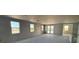 Bright living room with multiple windows with unfinished walls and concrete floors at 707 Junonia Blvd, New Smyrna Beach, FL 32168