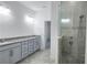 Bright bathroom featuring gray vanity with granite countertops and a glass-enclosed shower with tiled walls at 726 Coral Reef Way, Daytona Beach, FL 32124