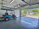 Garage with overhead storage and a golf cart, open to a sunny street at 726 Coral Reef Way, Daytona Beach, FL 32124