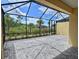 Screened-in lanai with a paver patio offering a relaxing outdoor living space with lush landscaping views at 726 Coral Reef Way, Daytona Beach, FL 32124