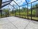 Screened-in lanai with a paver patio offering a relaxing outdoor living space with lush landscaping views at 726 Coral Reef Way, Daytona Beach, FL 32124