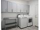 Well-equipped laundry room featuring built-in cabinets, stainless steel table and modern washer and dryer at 726 Coral Reef Way, Daytona Beach, FL 32124