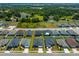 An aerial view showcasing the home's position within a quiet residential neighborhood surrounded by lush greenery at 871 Orleans Dr, Eagle Lake, FL 33839