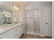 Bright bathroom with dual sinks, white cabinetry, and tiled walk-in shower at 871 Orleans Dr, Eagle Lake, FL 33839