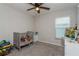 Well-lit bedroom with gray carpet, a window, and a comfortable crib with stuffed animals at 871 Orleans Dr, Eagle Lake, FL 33839