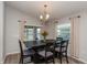 Cozy dining room with wood floors, modern lighting fixture, and sliding glass doors to the backyard at 871 Orleans Dr, Eagle Lake, FL 33839