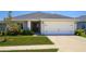 Charming single-story home with a well-manicured lawn and a two-car garage at 871 Orleans Dr, Eagle Lake, FL 33839