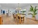 A spacious dining room with modern chandelier, light wood flooring, and an open layout to the kitchen at 107 Hilltop Dr, Longwood, FL 32750