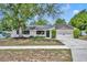 Inviting single-story home with a lush front yard, mature trees, and a two-car garage at 107 Hilltop Dr, Longwood, FL 32750