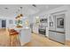 Bright kitchen featuring white cabinets, quartz countertops, stainless steel appliances, and seating at the island at 107 Hilltop Dr, Longwood, FL 32750