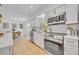 Modern kitchen with white cabinets, stainless steel appliances, and a view into the dining area at 107 Hilltop Dr, Longwood, FL 32750